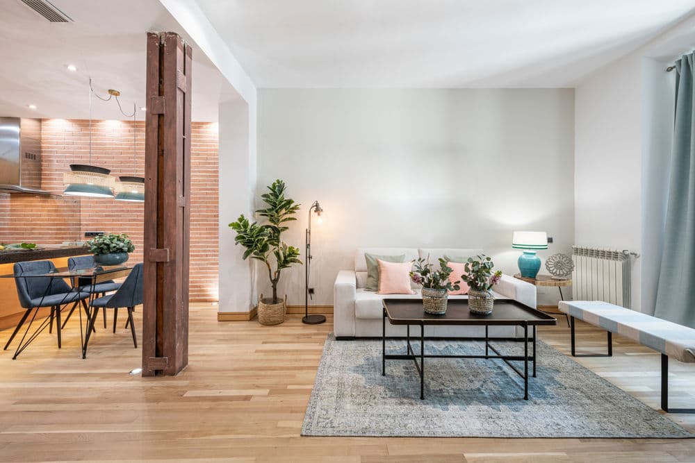 Modern living room with a white sofa, decorative plants, and a stylish coffee table.